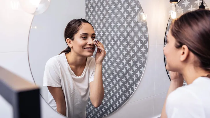 Businesswoman removing her makeup after tiring working day