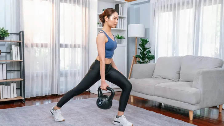 Vigorous energetic woman with dumbbell weight exercise at home.