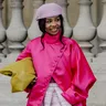 Street style foto van vrouw in roze Louis Vuitton outfit en groene tas tijdens Parijs Fashion Week 2026