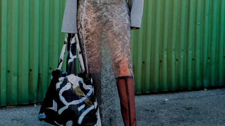Stijlvolle vrouw tijdens Fashion week in modieuze outfit en zebraprint tas.