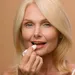 Vrouw brengt lipbalm aan op lippen.