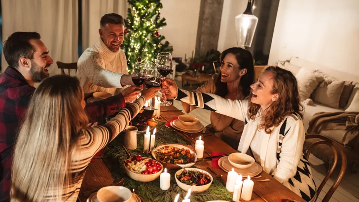 Familie aan tafel tijdens een gezellig kerstdiner: deze gesprekken kun je beter vermijden.