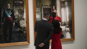 Felipe en Letizia bewonderen zichzelf op glamoureuze portretten. – Foto van rugaanzicht koning Felipe en koningin Letizia bij hun eigen foto's in de Spaanse Bank.
