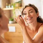 Beautiful woman applying mascara