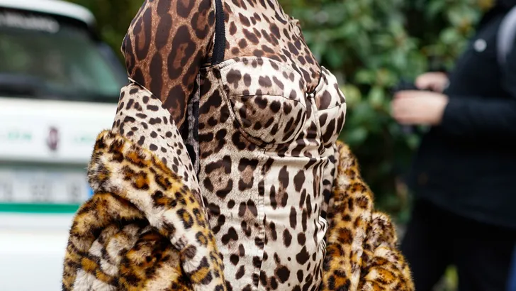 Vrouw draagt jas met panterprint.