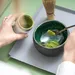 Foto van vrouw die matcha maakt.