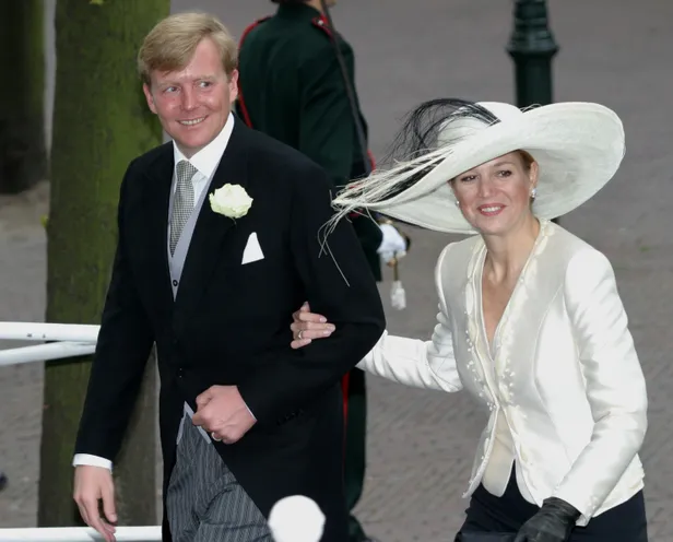 Máxima aan arm van Willen-Alexander in wit jasje en zwarte hoed tijdens huwelijk van prins Friso and Mabel 