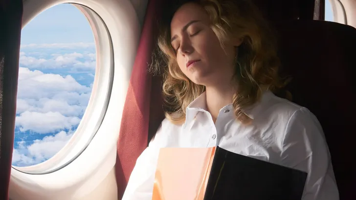 young woman dozed off in the cabin of a flying plane