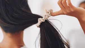 Vrouw haalt haar elastiek uit haar haren.