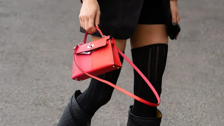 Paris, France - October, 1, 2022: woman wearing black leather Kelly handbag from Hermes, street style outfit.