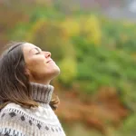 Middle aged woman breathing fresh air in a forest