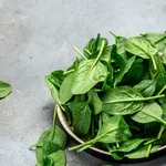 Close up Spinach. Raw organic fresh baby spinach leaves in a metal bowl on dark background. Food recipe background., top view