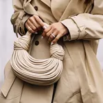 Weekendtips van Beau Monde – close-up foto van beige handtas en trenchcoat.