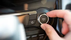 Hand draait de airconditioning van een auto naar MAX A/C