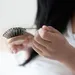 Vrouw haalt haar uit haar haarborstel.