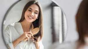 Beauty Routine. Pretty Woman Combing Her Beautiful Hair With Brush
