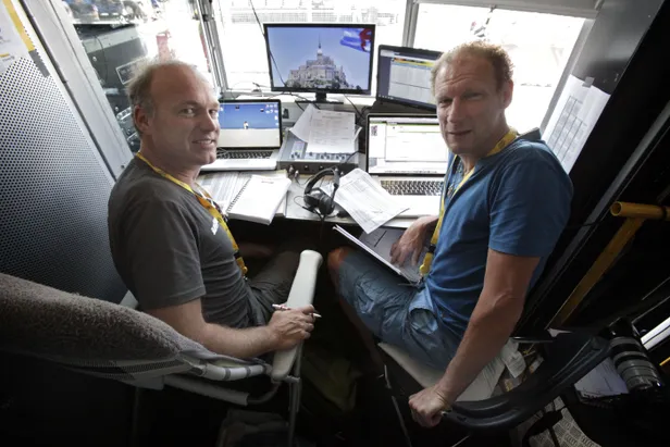 Herbert Dijkstra en Maarten Ducrot met koptelefoons op in het commentaarhokje van de NOS tijdens de Tour de France.