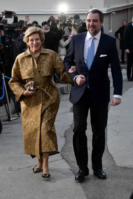 De bruidegom, prins Nikolaos, arriveerde aan de arm van zijn moeder, koningin Anne-Marie.