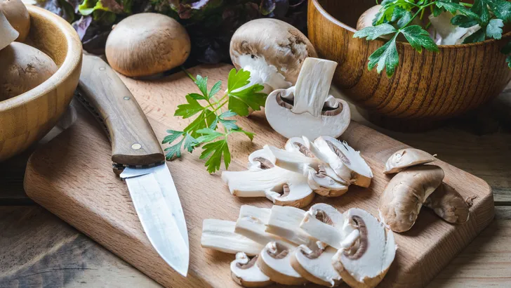 rauwe champignons op een snijplank