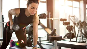 Fitness girl lifting dumbbell in the morning.