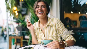 Vrouw geniet van kop koffie op het terras