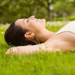 Peaceful fit brunette lying on the grass