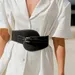 Riem in het zwart om witte blouse over bovenlichaam