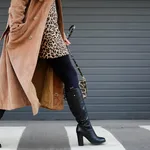 Stylish woman in black shoes walking across the street