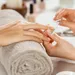 vrouwenhand die gevijld wordt bij manicure - velletjes bij nagels