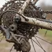 Modderige gravelbike-aandrijving met achterderailleur, cassette en ketting na een natte winterrit.