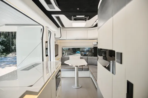Het moderne interieur combineert een complete keuken met een L-vormige zithoek die ook als slaapplaats kan dienen.
