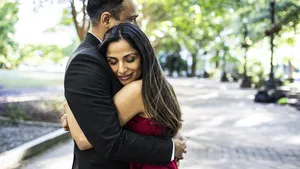 Married couple embracing in downtown park