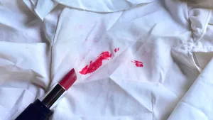 Stains of lipstick or makeup on white clothes or stains on clothes from everyday accidents. Concept of cleaning stains on clothes or cleaning the house. Selected focus