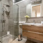 Badkamer met douchecabine, wastafel en toiletartikelen