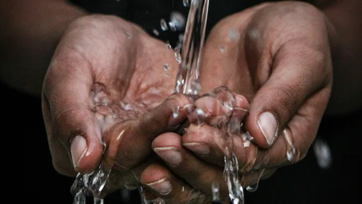 Handen waar water in stroomt - waterverbruik