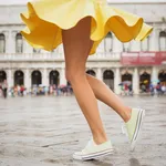 Young woman with sexy legs and yellow skirt