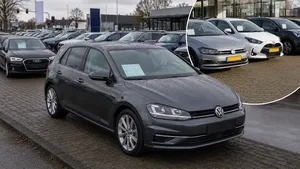 Rijen occasions op een Nederlands autoterrein naast een showroom