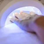 Female hand in the lamp for manicure