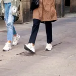 Young elegant women walking on the street wearing sport shoes.