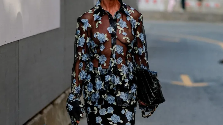 Oudere vrouw met bloemenjurk tijdens Fashion Week.