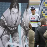 van der poel en pedersen bij een grote poster van eddy merckx