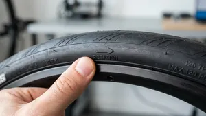 Macro-opname van de zijkant van een racefietsband, gefocust op de ingegoten 'Rotation' pijl die de draairichting aangeeft.