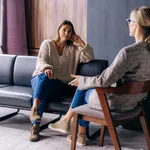 A young woman in a consultation with a psychologist listens to advice on improving behavior in life.