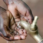 Kinderhandjes onder waterkraan