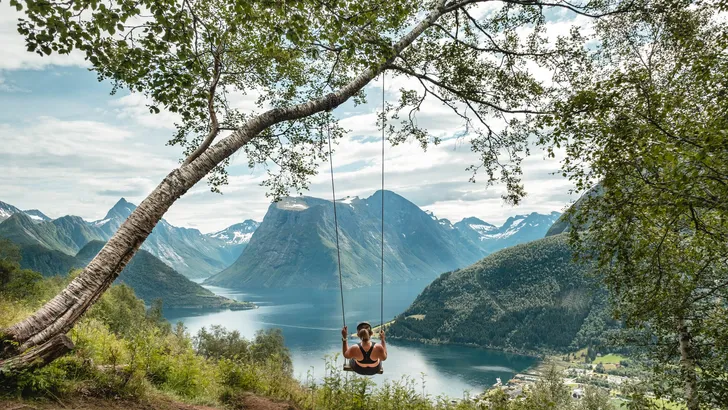 Woman swinging into nature in Norway.