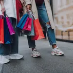 Young women with shopping bags standing on the street