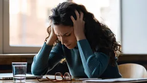 Unhappy woman overworked stressed sit at desk with closed laptop suffer from headache or depression