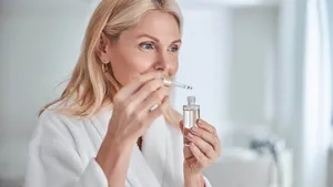 Pretty elegant female with face skin care in hand in bathroom