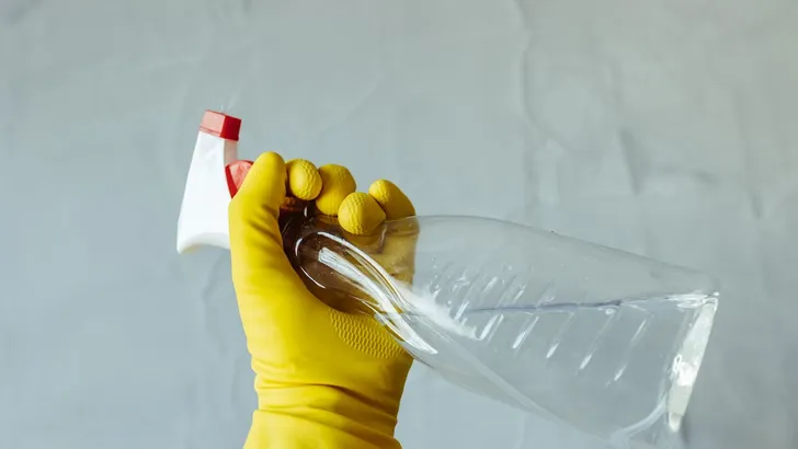 Foto van hand met sprayfles schoonmaakmiddel bij voorjaarsschoonmaak