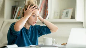 Portrait of an attractive woman at table grabbing her head